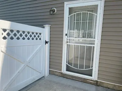 a white door with a gate in front of a house at Angelica peaceful place in West Haven