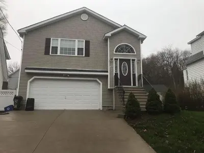 a brown house with a door and a garage at Angelica peaceful place in West Haven