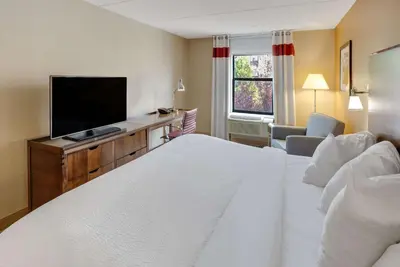 a hotel room with a bed and a flat screen tv at The Crossroads Hotel - Newburgh in Newburgh