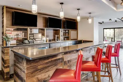 a bar with red chairs in a kitchen with a counter at The Crossroads Hotel - Newburgh in Newburgh