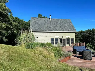 a white house with two blue chairs on a deck at SRC-Hudson Valley, Berkshires Cultural Corridor in Canaan