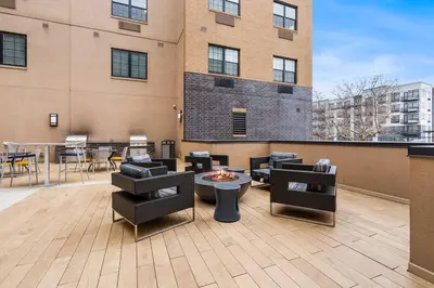 a rooftop patio with chairs and a fire pit on a building at Supreme 2 Bedroom Condo in Prime Jersey City in Jersey City