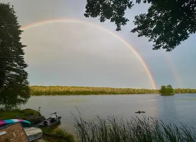 a rainbow over a lake with boats in the water at Mountain Lake Retreat in Clifton