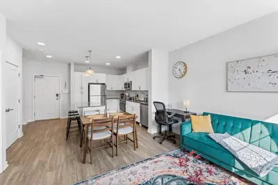 a living room with a blue couch and a table at Jersey City's Best Enjoy Our Deluxe 1 Bedroom Condo Only 25 Minutes to NYC in Jersey City