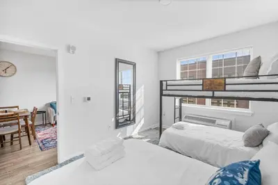 a bedroom with two beds and a dining room at Luxury Living in Jersey City Only Steps Away from Manhattan in Jersey City