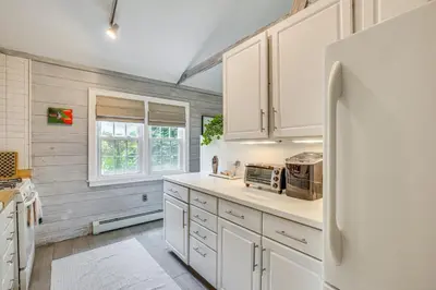 a kitchen with white cabinets and a refrigerator at Serene Holmes Cottage Near Lakes and Trails! in Pawling