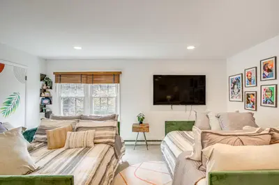 a living room with two couches and a flat screen tv at Serene Holmes Cottage Near Lakes and Trails! in Pawling