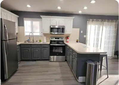 a kitchen with stainless steel appliances and gray cabinets at Vdara Pocono Home in Tobyhanna
