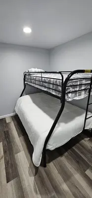 a bunk bed in a room with a wooden floor at Aria Pocono Home in Tobyhanna