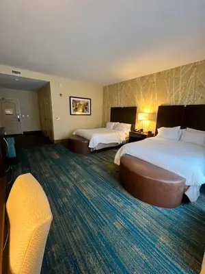 a hotel room with two beds and a couch at Hampton Inn & Suites Stroudsburg Bartonsville Poconos in Stroudsburg