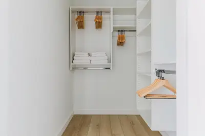 a walk in closet with white walls and wooden floors at Blueground Jersey City gym wd ac games NYC-1580 in New York