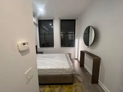 a small room with a bed and a mirror at Luxury 2 BD unit in Financial District in New York