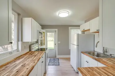 a kitchen with white cabinets and a wooden counter top at 2 Mi to Windham Mountain Scenic Home with Fire Pit! in Windham