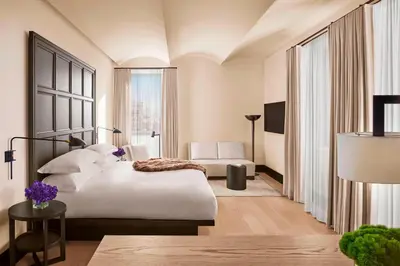 a hotel room with a bed and a large window at The New York EDITION in New York