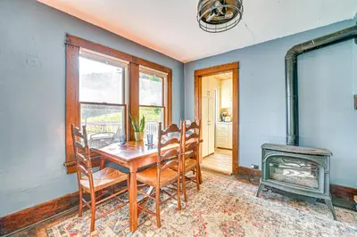 a dining room with a table and a wood stove at Pet-Friendly Catskills Retreat Fire Pit and Deck! in Grand Gorge
