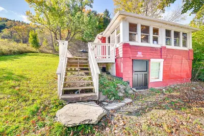 a red house with a staircase in a yard at Pet-Friendly Catskills Retreat Fire Pit and Deck! in Grand Gorge