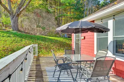 a table and chairs on a porch with an umbrella at Pet-Friendly Catskills Retreat Fire Pit and Deck! in Grand Gorge