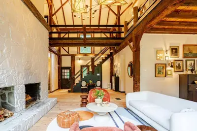 a living room with a couch and a fireplace at Unique Fully Restored Landmark Barn in Hudson in Claverack