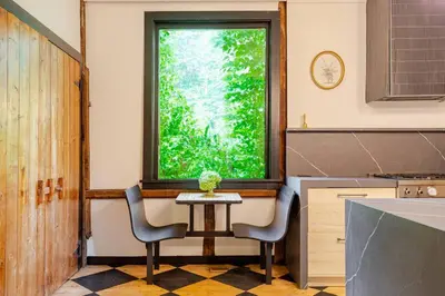 a kitchen with a table and two chairs and a window at Unique Fully Restored Landmark Barn in Hudson in Claverack