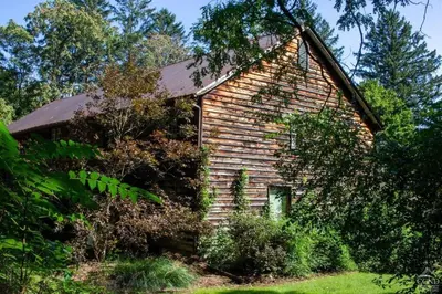 an old brick house in the middle of a yard at Unique Fully Restored Landmark Barn in Hudson in Claverack