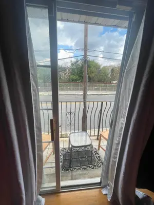 a room with a window with a chair on a balcony at 4 bedroom apt in Newark in Newark