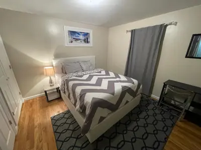 a bedroom with a bed with a black and white comforter at 4 bedroom apt in Newark in Newark