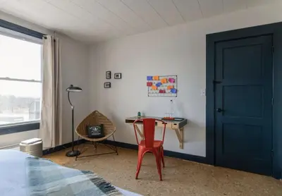 a bedroom with a red chair and a desk at The Arnold House in Livingston Manor