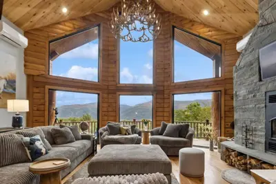 a living room with a fireplace and large windows at Snow Nirvana in Hunter
