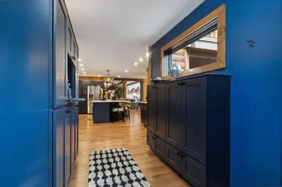 a blue kitchen with a black cabinet and a checkered rug at Snow Nirvana in Hunter