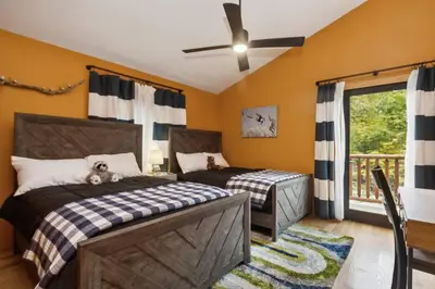 a bedroom with two beds and a ceiling fan at Snow Nirvana in Hunter