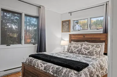a bedroom with a bed and two windows at Mt Snow Retreat - Walk to brewery in Dover