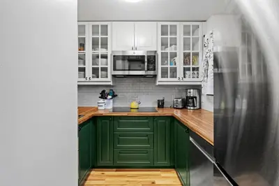 a kitchen with green cabinets and a stainless steel refrigerator at Mt Snow Retreat - Walk to brewery in Dover