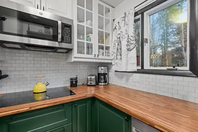a kitchen with green cabinets and a wooden counter top at Mt Snow Retreat - Walk to brewery in Dover