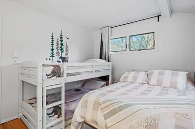 a bedroom with a white bunk bed with a striped blanket at Mt Snow Retreat - Walk to brewery in Dover