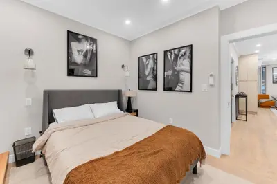 a bedroom with a large bed with four pictures on the wall at Modern 3Bd Rose Hills Manhattan Terrace Space in New York