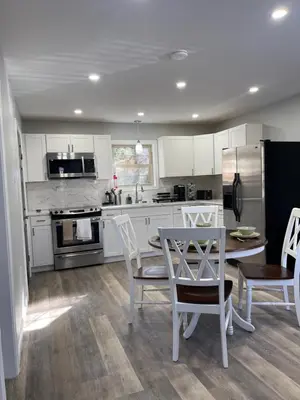 a kitchen with white cabinets and a table and chairs at Cabin near kalahari,camelback Ski in Long Pond