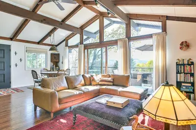 a living room with a leather couch and a table at Cozy Mtn-View Chalet Less Than 2 Mi to Windham Slopes in Windham