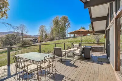 a deck with chairs and tables and an umbrella at Cozy Mtn-View Chalet Less Than 2 Mi to Windham Slopes in Windham