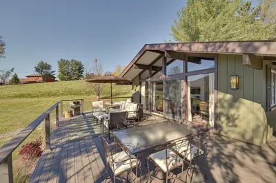 a deck with chairs and an umbrella on a house at Cozy Mtn-View Chalet Less Than 2 Mi to Windham Slopes in Windham