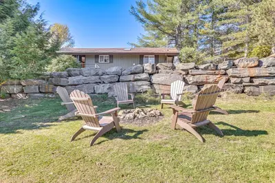 three chairs sitting in the grass near a stone wall at Cozy Mtn-View Chalet Less Than 2 Mi to Windham Slopes in Windham