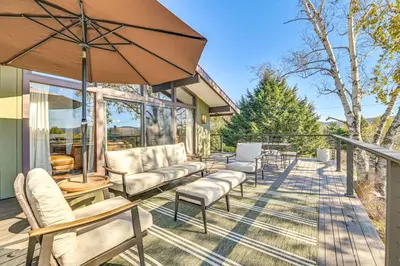 a patio with chairs and an umbrella at Cozy Mtn-View Chalet Less Than 2 Mi to Windham Slopes in Windham