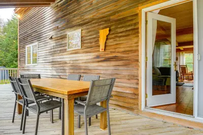 a wooden dining table and chairs on a wooden deck at Home 15 Mi to Berkshire East and Mount Snow! in Whitingham
