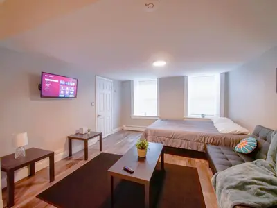 a living room with a bed and a couch at Bright and Airy Studio Apt Minutes to NYC in Jersey City