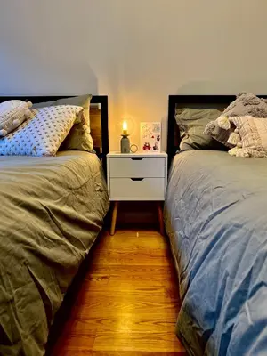 a bedroom with two beds and a nightstand between them at Cozy apartment in New York in Woodside