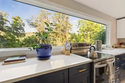 a kitchen with a large window with a potted plant at Classic Country 6 Bedroom in Kingston