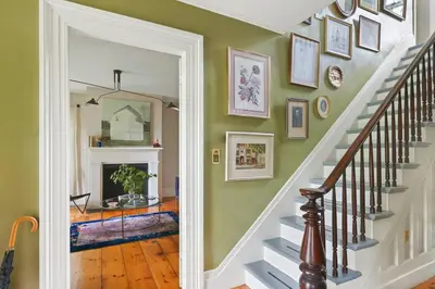 a staircase in a home with a mirror and pictures on the wall at Classic Country 6 Bedroom in Kingston