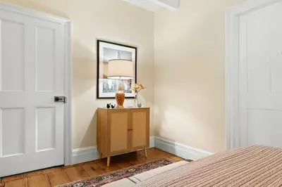 a bedroom with a bed and a table with a lamp at Classic Country 6 Bedroom in Kingston