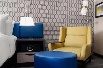a bedroom with a bed and a chair and a tv at GLō Best Western Bronx NYC in Bronx