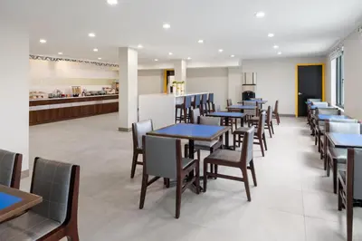 a row of tables and chairs in a restaurant at GLō Best Western Bronx NYC in Bronx