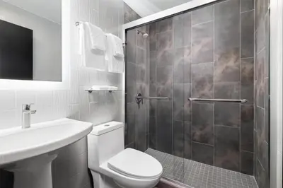 a bathroom with a shower and a toilet and a sink at GLō Best Western Bronx NYC in Bronx